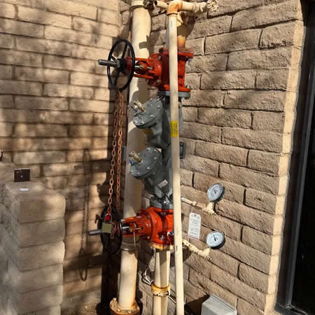 Technician checking a fire riser pressure gauge